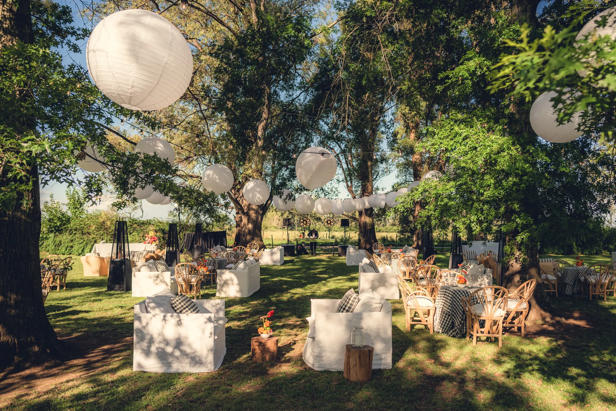 Outdoor design setup under trees with hanging lanterns